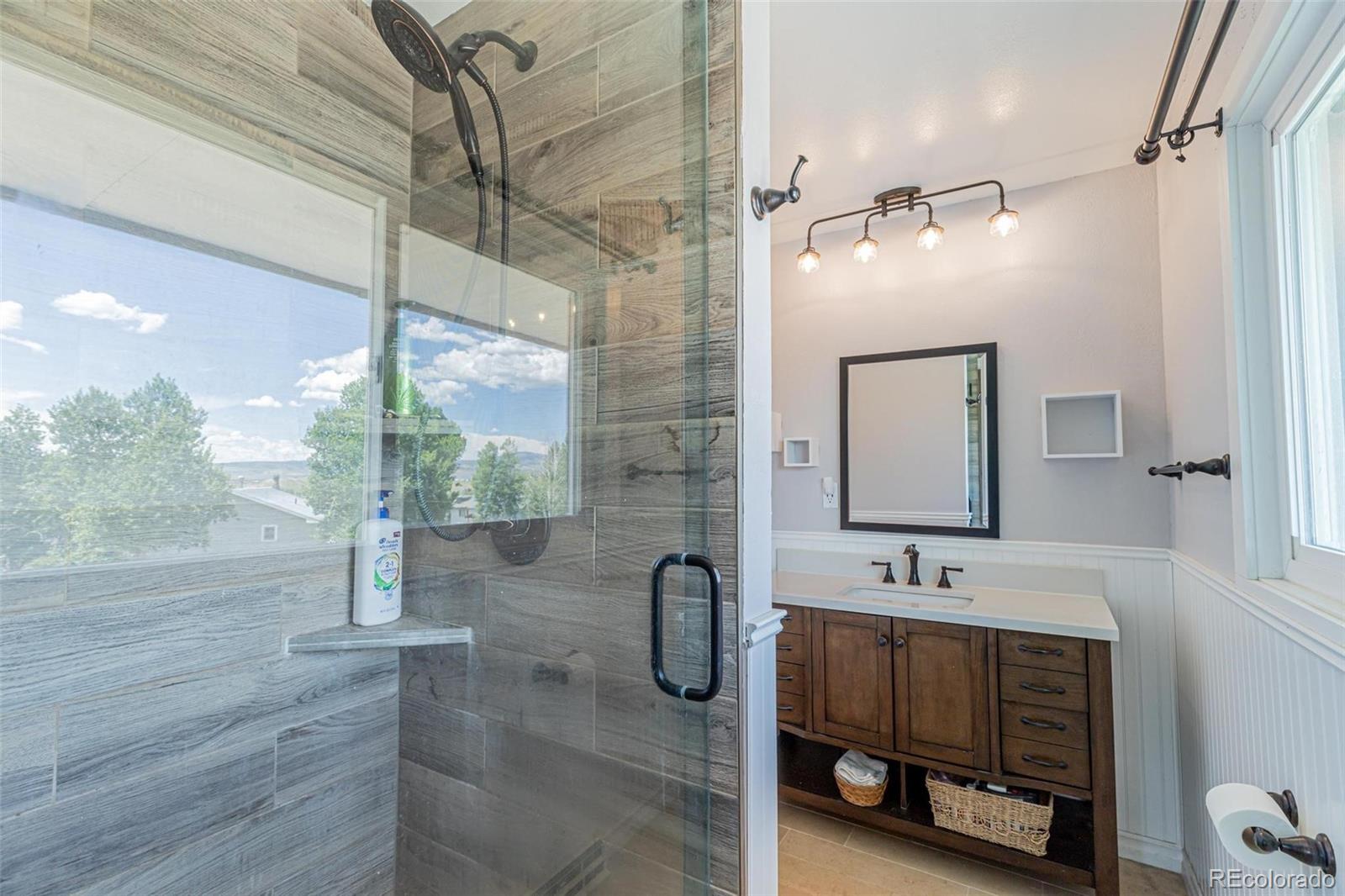 420 Clover Circle Hayden, CO 81639 - Photo 18 of 37 a bathroom with a double vanity sink a mirror and shower
