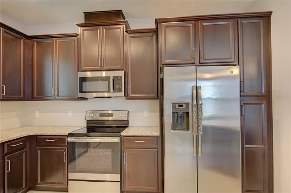 a kitchen with a refrigerator and a stove top oven