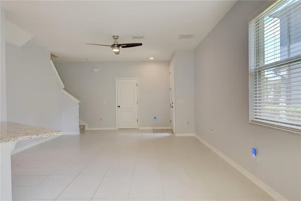 an empty room with windows and fan