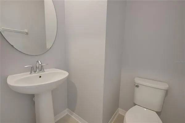 a bathroom with a sink a toilet and mirror