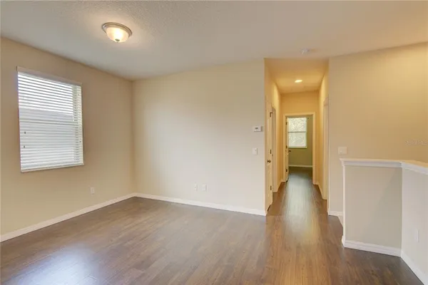 an empty room with a window and wooden floor