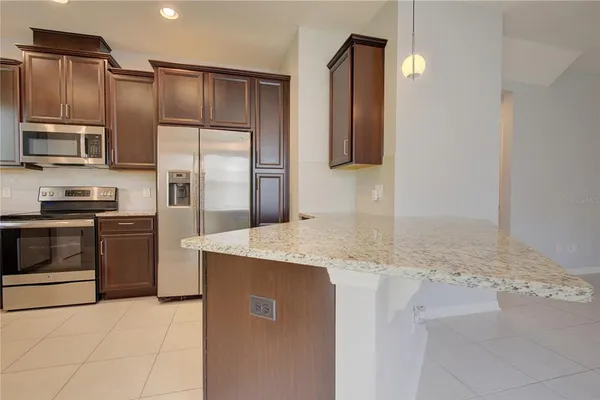 a kitchen with stainless steel appliances granite countertop a refrigerator and a stove