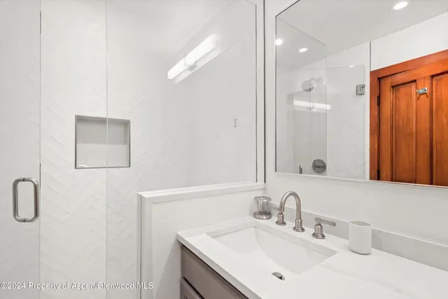 a bathroom with a double vanity sink mirror and shower