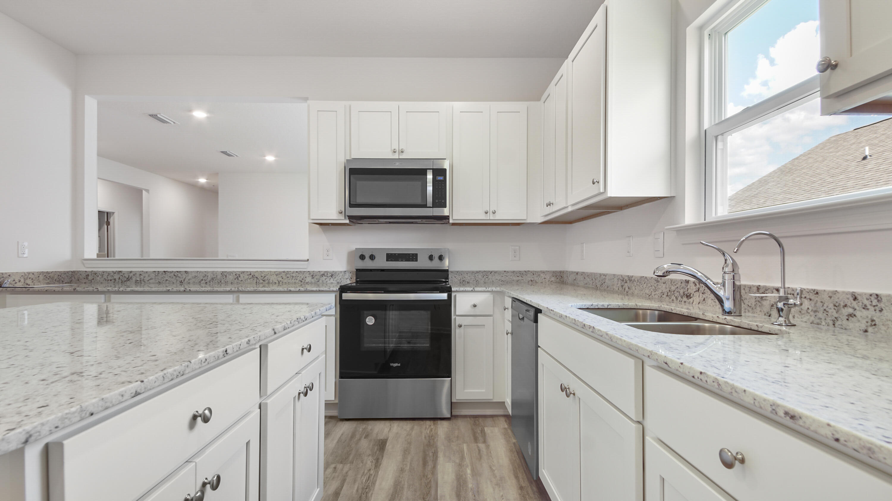 205 Huckleberry Street Freeport, FL 32439 - Photo 10 of 32 a kitchen with granite countertop a sink a stove and cabinets