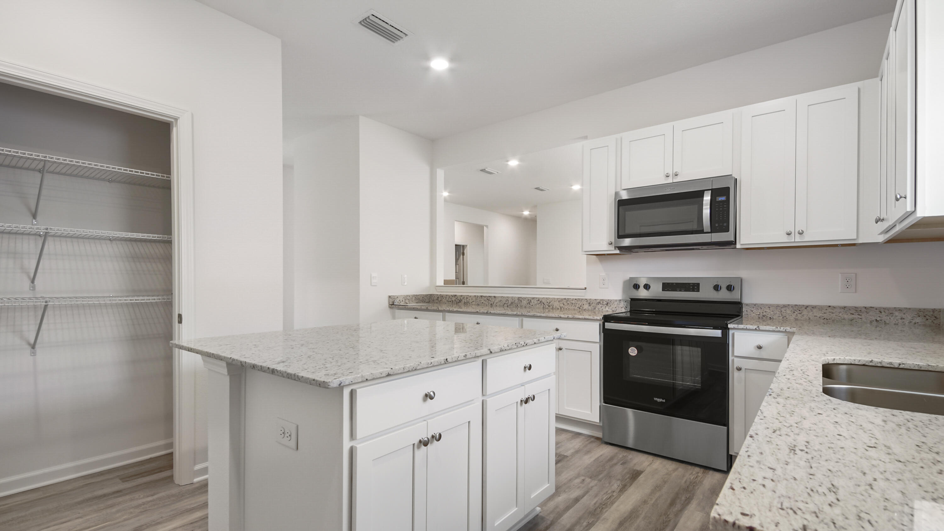205 Huckleberry Street Freeport, FL 32439 - Photo 12 of 32 a kitchen with stainless steel appliances granite countertop a stove a sink and a microwave