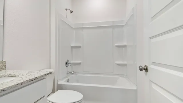 a bathroom with a granite countertop toilet sink and bathtub