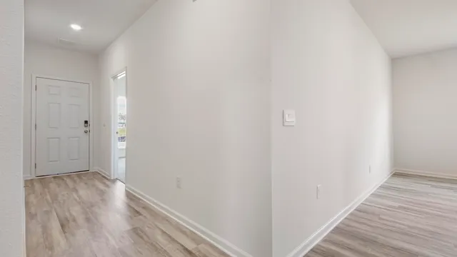 a view of a hallway with wooden floor