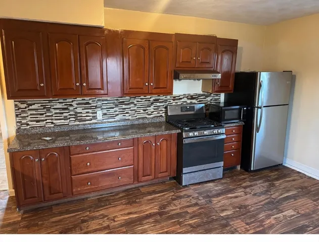a kitchen with granite countertop wooden cabinets and stainless steel appliances