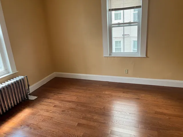 a view of a room with wooden floor and windows
