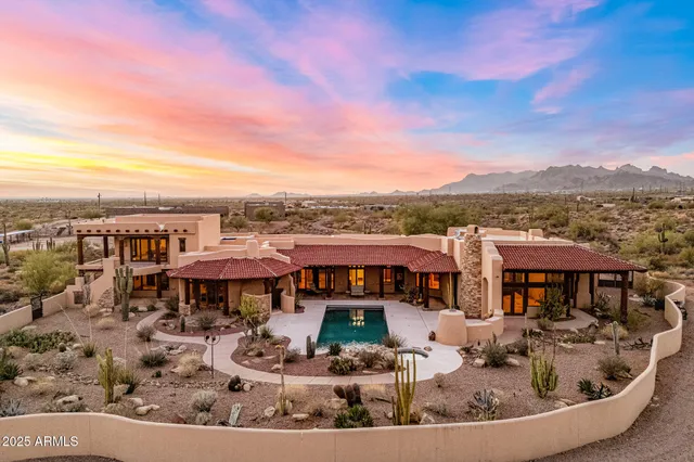 a aerial view of a house with swimming pool and mountains