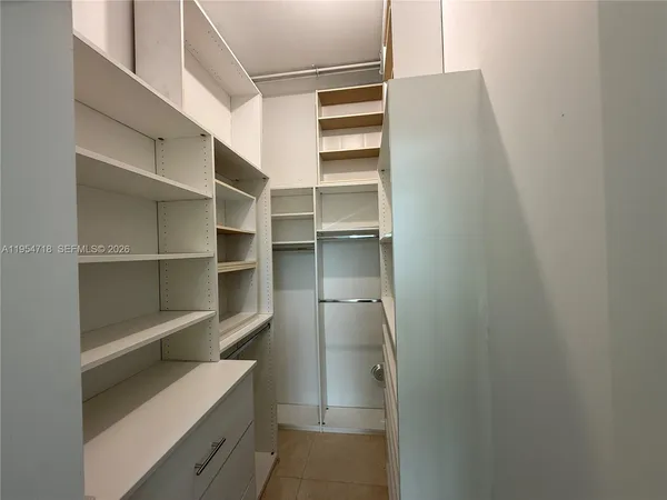 a view of walk in closet with empty racks
