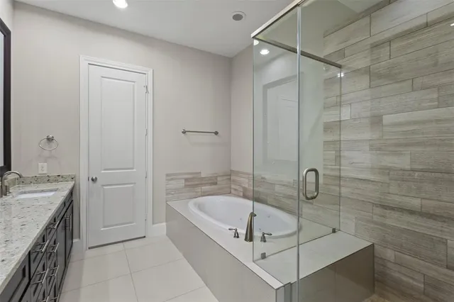 a bathroom with a tub a sink a vanity and a shower