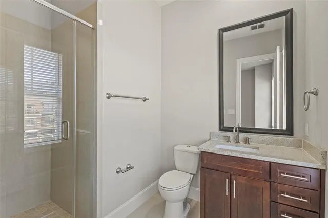 a bathroom with a granite countertop sink toilet and mirror