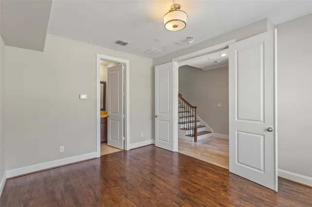 an empty room with wooden floor and staircase