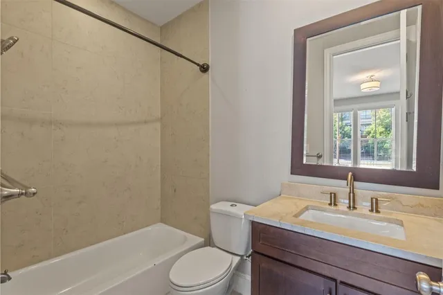 a bathroom with a granite countertop sink toilet a mirror and shower