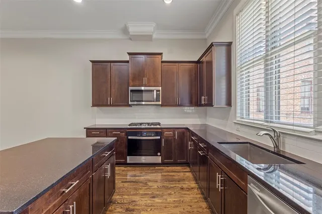 a kitchen with stainless steel appliances a sink stove and cabinets