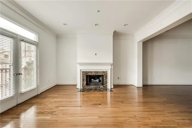a view of a livingroom with wooden floor a fireplace and window