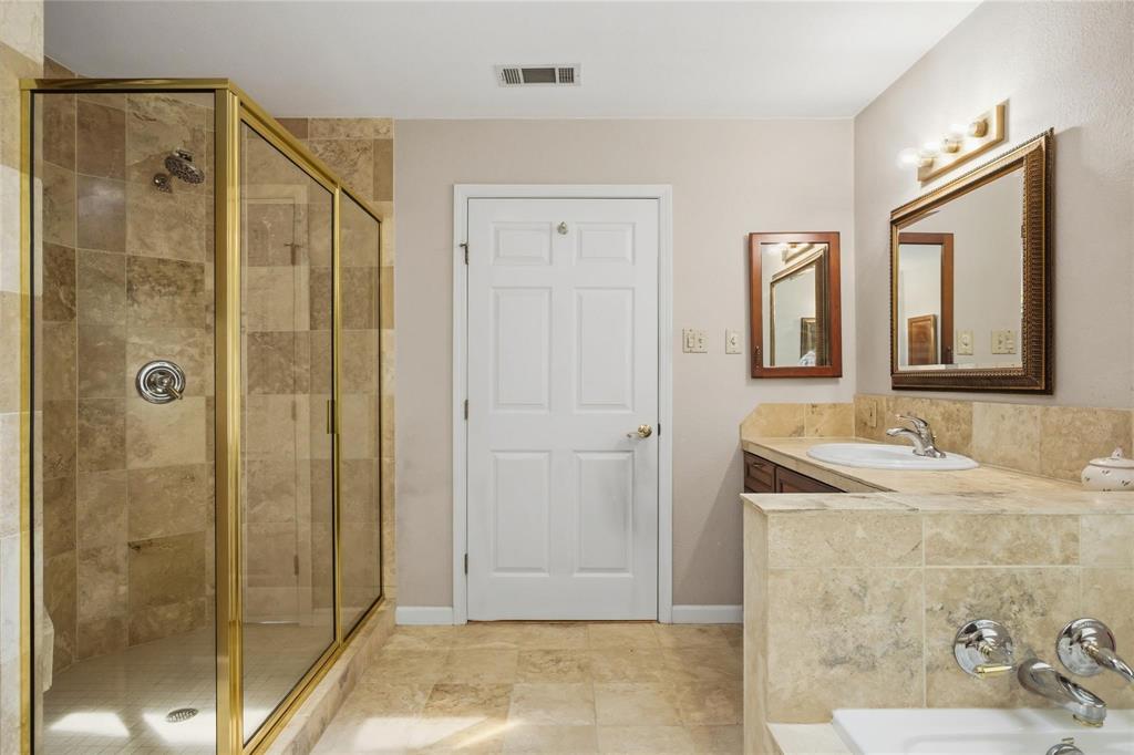 265 East Dove Road Southlake, TX 76092 - Photo 20 of 39 a bathroom with a granite countertop sink a mirror and shower