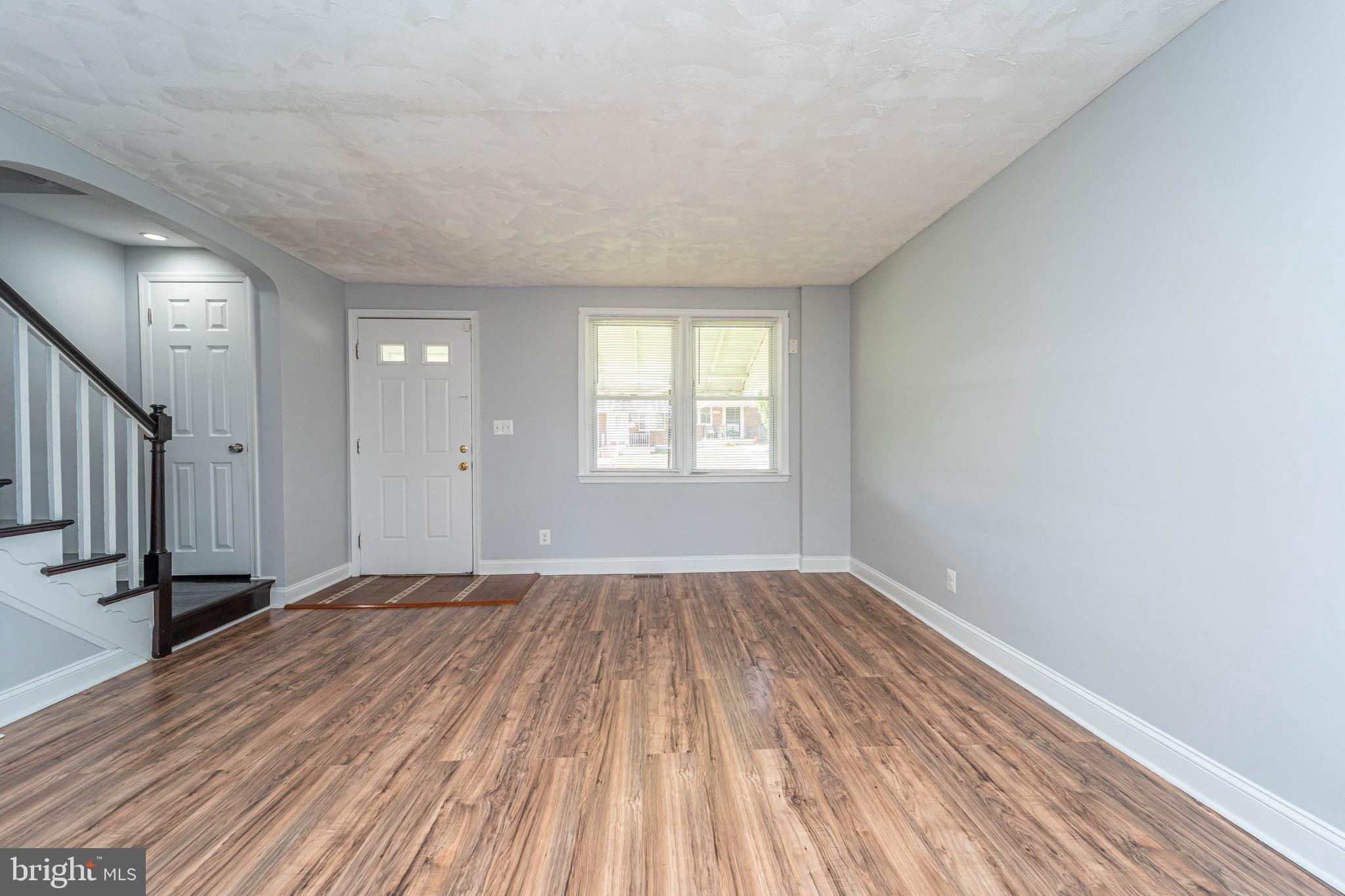 919 Kevin Road Baltimore, MD 21229 - Photo 8 of 38 a view of an empty room with wooden floor and a window