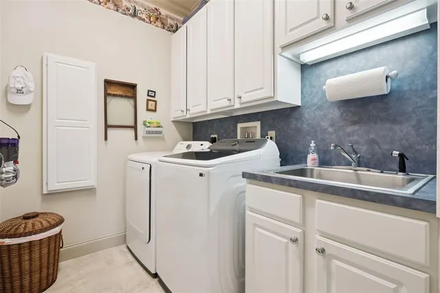 a kitchen with white cabinets and sink