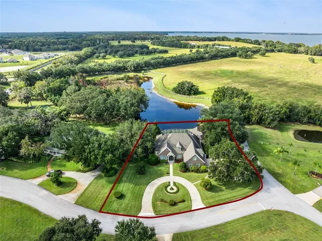 an aerial view of a house with a garden and lake view