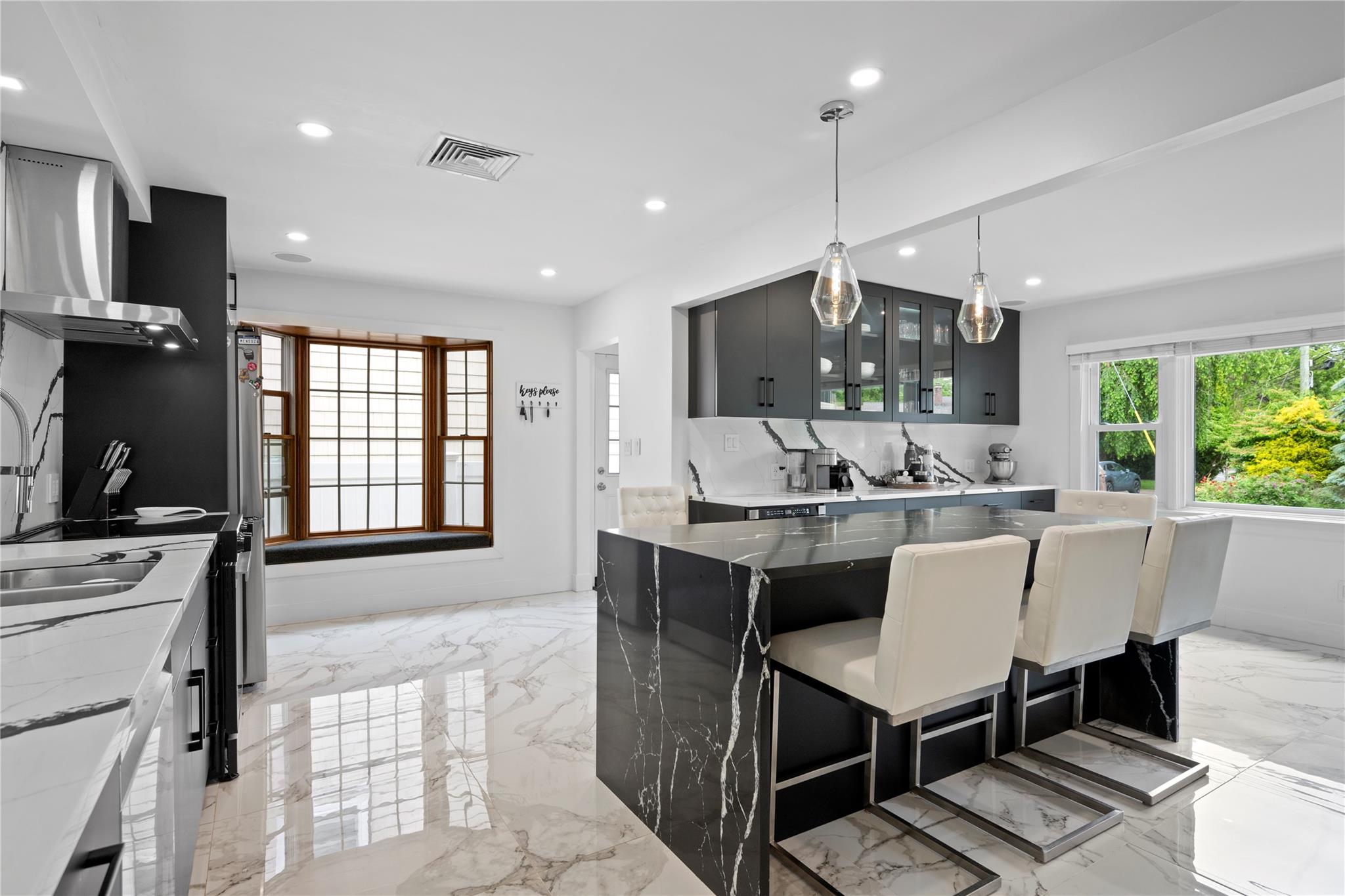 1 Bennett Avenue Huntington, NY 11746 - Photo 3 of 24 Kitchen with light marble finish flooring, recessed lighting, glass insert cabinets, pendant lighting, and wall chimney exhaust hood