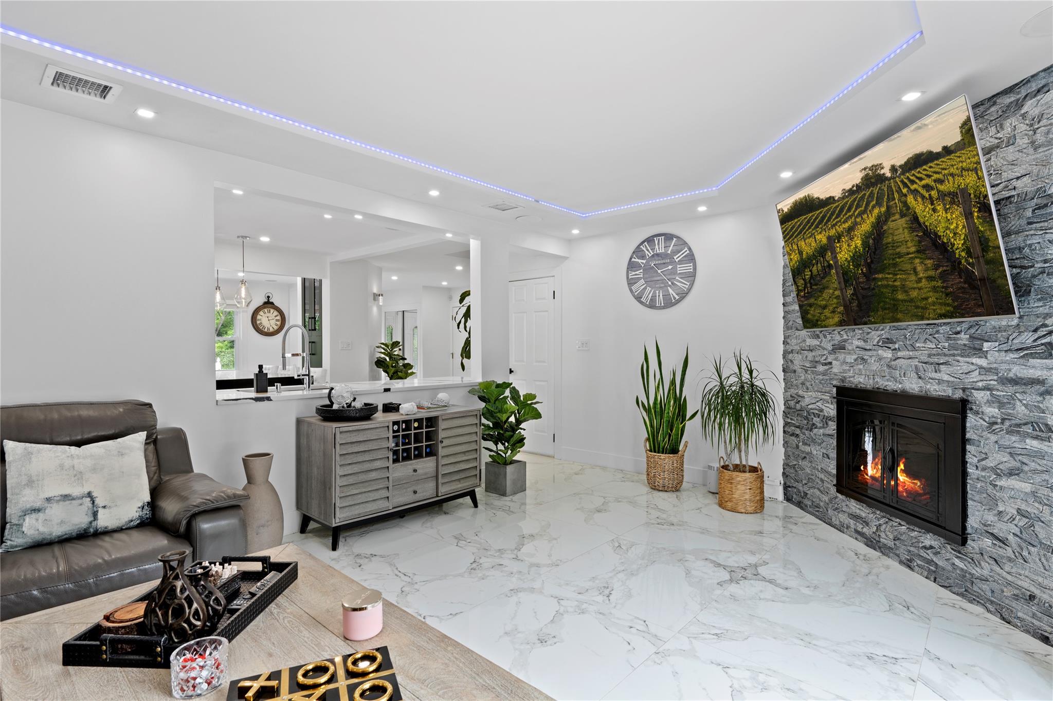 1 Bennett Avenue Huntington, NY 11746 - Photo 7 of 24 Living room featuring recessed lighting, a fireplace, a raised ceiling, and marble tiled floors