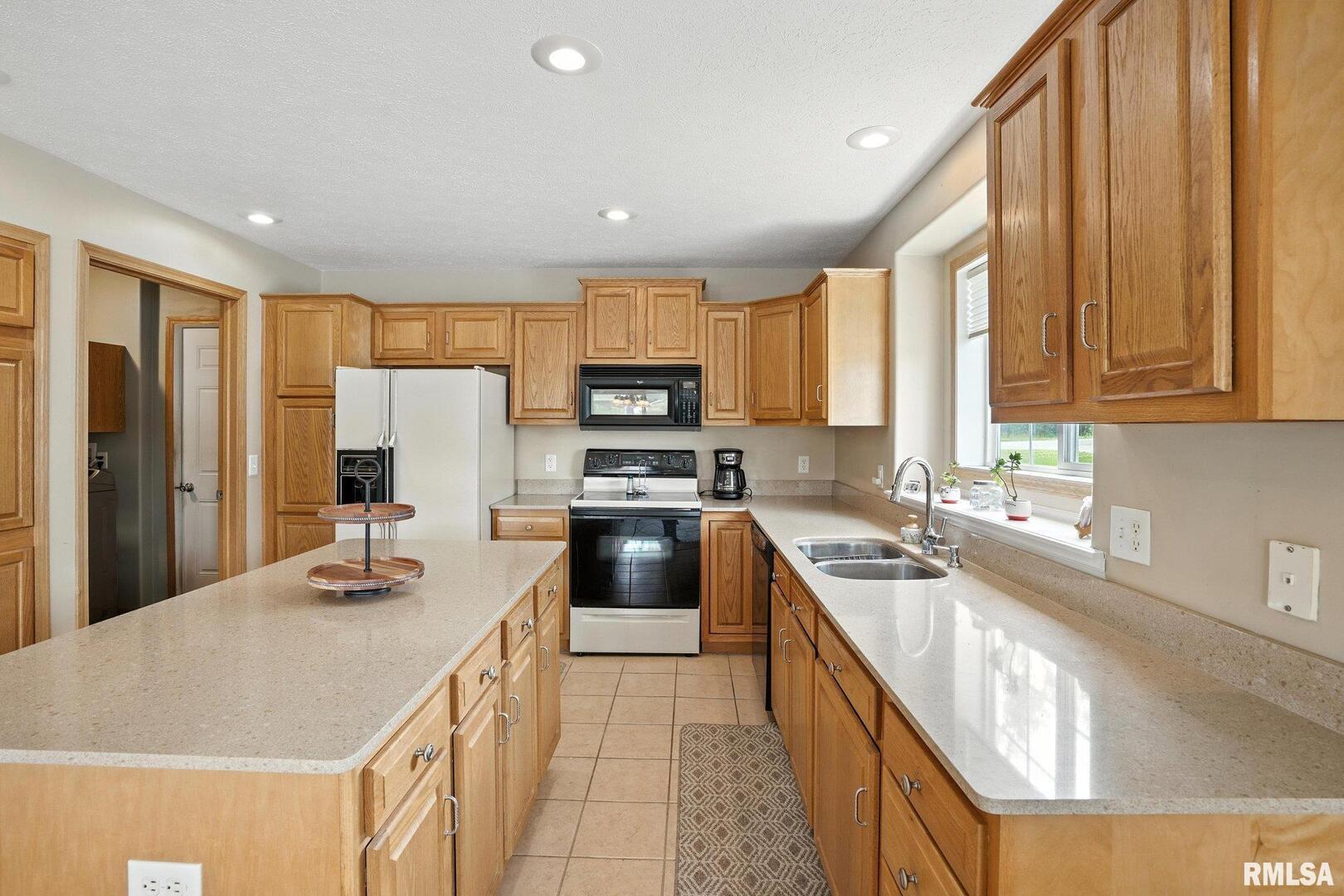 106 Valley View Drive Sherrard, IL 61281 - Photo 11 of 35 a kitchen with a stove a sink a microwave a refrigerator and cabinets