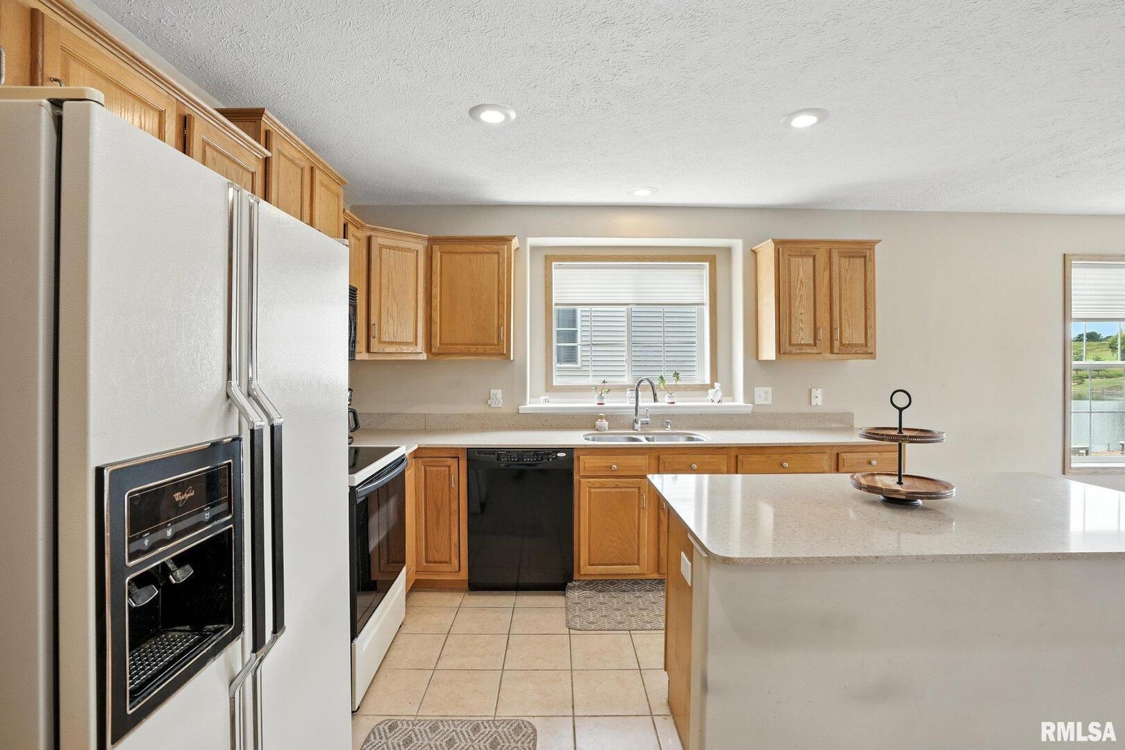 106 Valley View Drive Sherrard, IL 61281 - Photo 13 of 35 a kitchen with stainless steel appliances granite countertop a sink stove and refrigerator