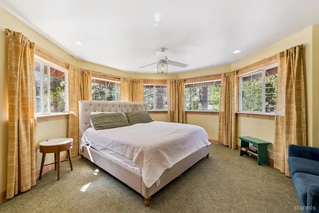 a bedroom with a bed chair and a large window