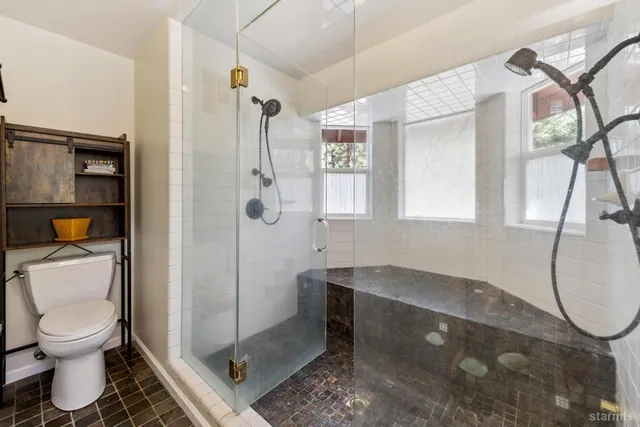 a bathroom with a toilet and a shower
