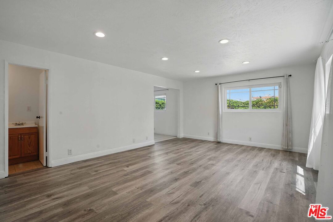 2108 Hauser Boulevard Los Angeles, CA 90016 - Photo 4 of 23 an empty room with wooden floor and windows
