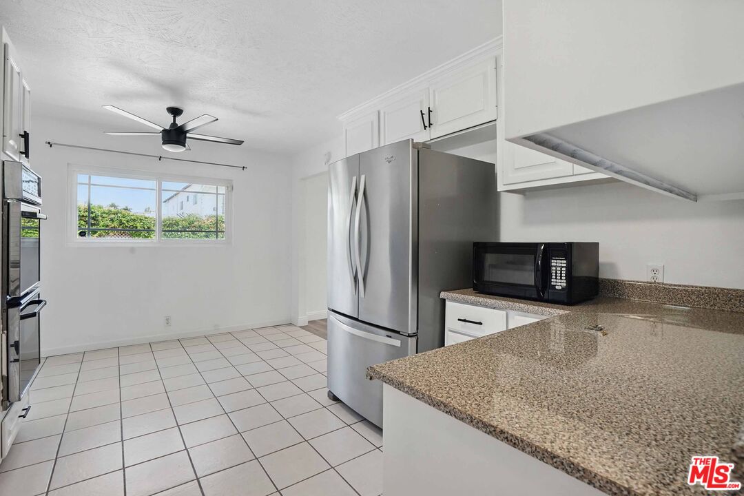 2108 Hauser Boulevard Los Angeles, CA 90016 - Photo 8 of 23 a kitchen with stainless steel appliances granite countertop a refrigerator a stove and a sink