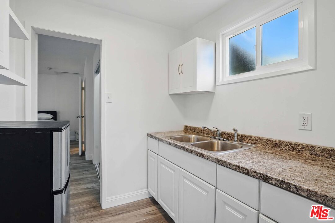 2108 Hauser Boulevard Los Angeles, CA 90016 - Photo 9 of 23 a kitchen with granite countertop a sink and cabinets