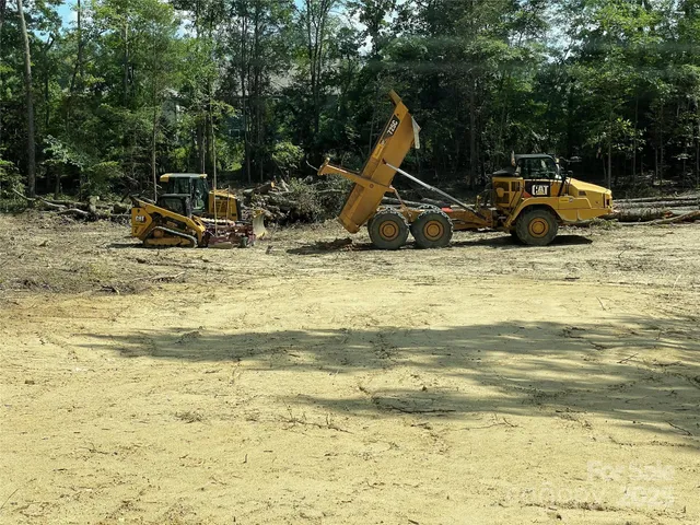 a view of a swimming pool with a slide and wooden fence