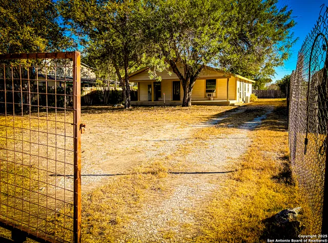 a view of a patio with table and chairs and wooden fence