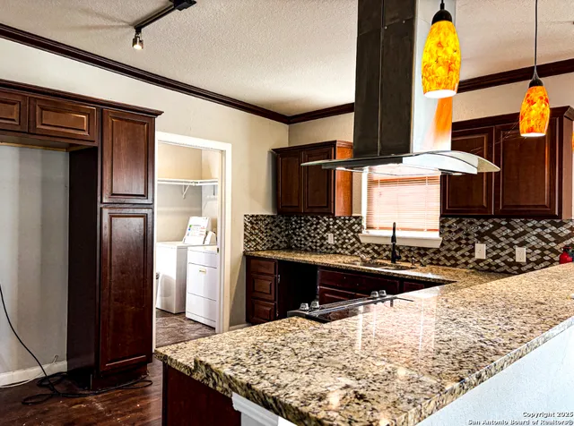 a kitchen with stainless steel appliances kitchen island granite countertop a refrigerator and stove