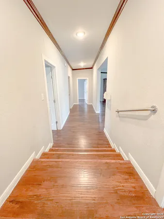 a view of a hallway with wooden floor and staircase