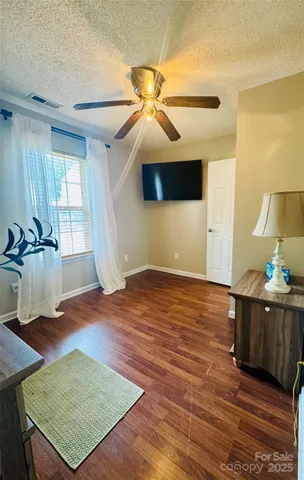 a view of a room with wooden floor and ceiling fan
