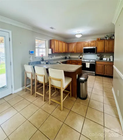 a open kitchen with stainless steel appliances kitchen island granite countertop a sink and cabinets
