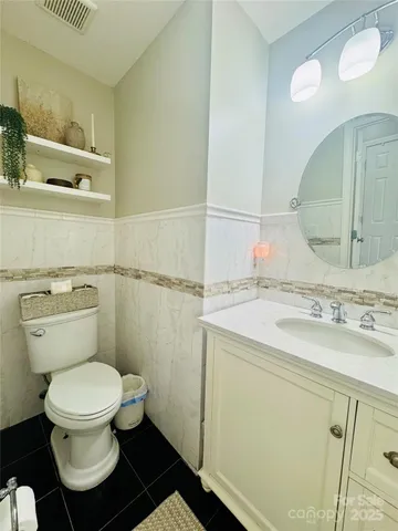 a bathroom with a granite countertop toilet sink and mirror