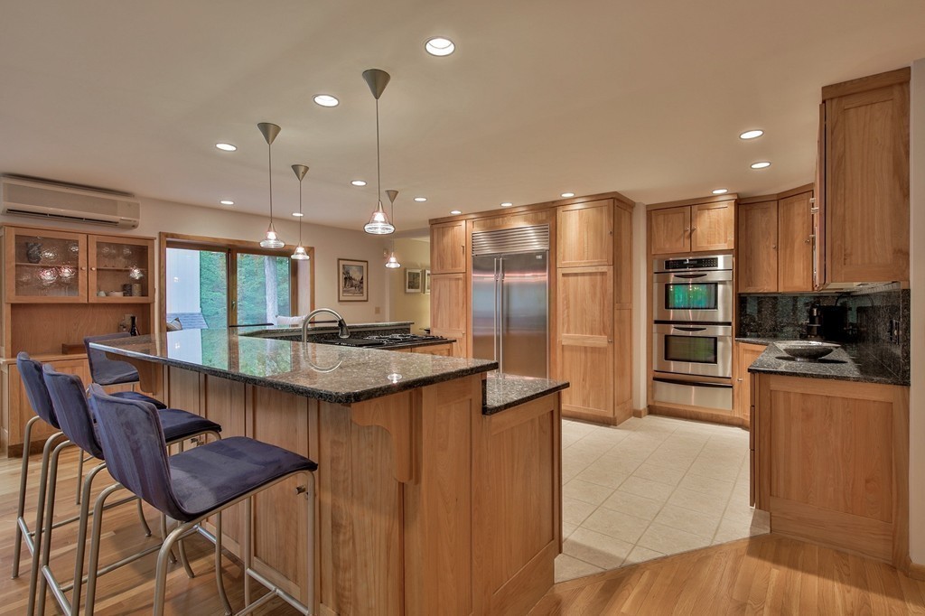 215 Littleton Road Harvard, MA 01451 - Photo 4 of 29 a kitchen with stainless steel appliances kitchen island granite countertop a table chairs in it and wooden floors