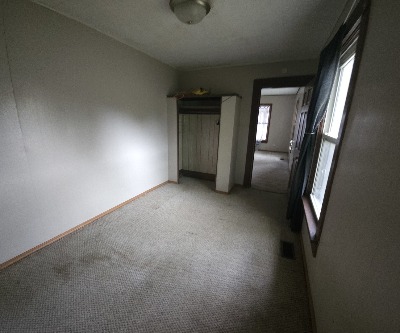 303 South Spruce Street Villa Grove, IL 61956 - Photo 5 of 10 a view of an empty room with wooden floor and a window