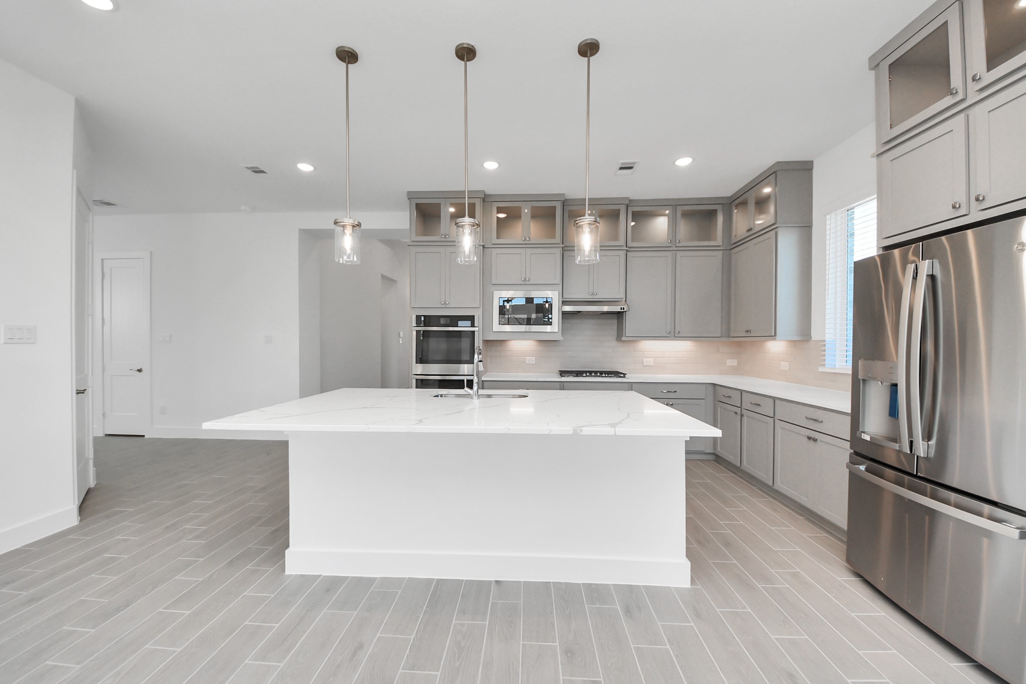 9507 Chateau Hill Manvel, TX 77578 - Photo 7 of 32 a large kitchen with stainless steel appliances a large counter top a stove a sink and a refrigerator