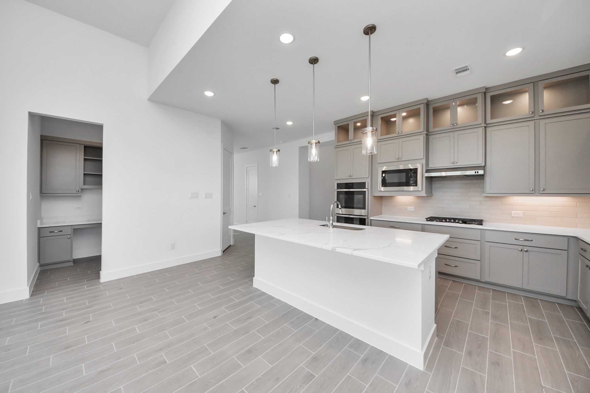 9507 Chateau Hill Manvel, TX 77578 - Photo 8 of 32 a large white kitchen with stainless steel appliances granite countertop a stove a sink dishwasher a microwave oven and a dining table with wooden floor