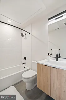 a bathroom with a toilet a sink a mirror and shower