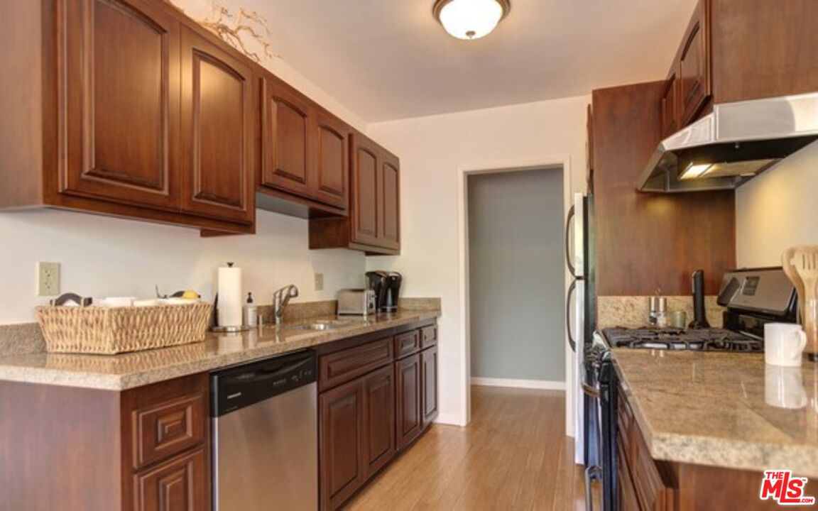 852 17th Street, Unit 3 Santa Monica, CA 90403 - Photo 4 of 8 a kitchen with stainless steel appliances granite countertop a sink stove and refrigerator