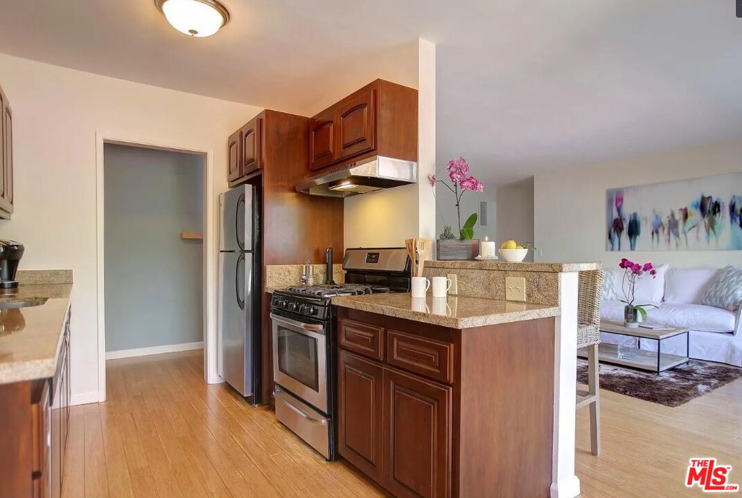852 17th Street, Unit 3 Santa Monica, CA 90403 - Photo 5 of 8 a kitchen with stainless steel appliances granite countertop a stove and a refrigerator