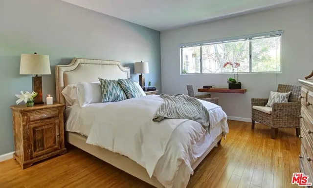 a bed sitting in a bedroom next to a window and wooden floor