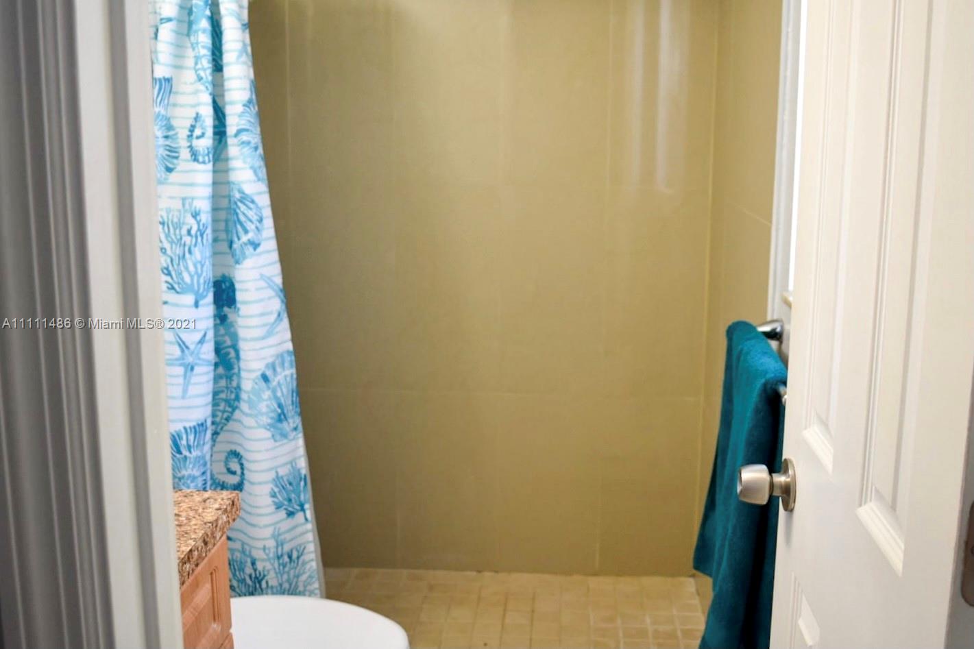 18280 Mediterranean Boulevard, Unit 43 Hialeah, FL 33015 - Photo 19 of 28 a bathroom with a toilet and shower curtain
